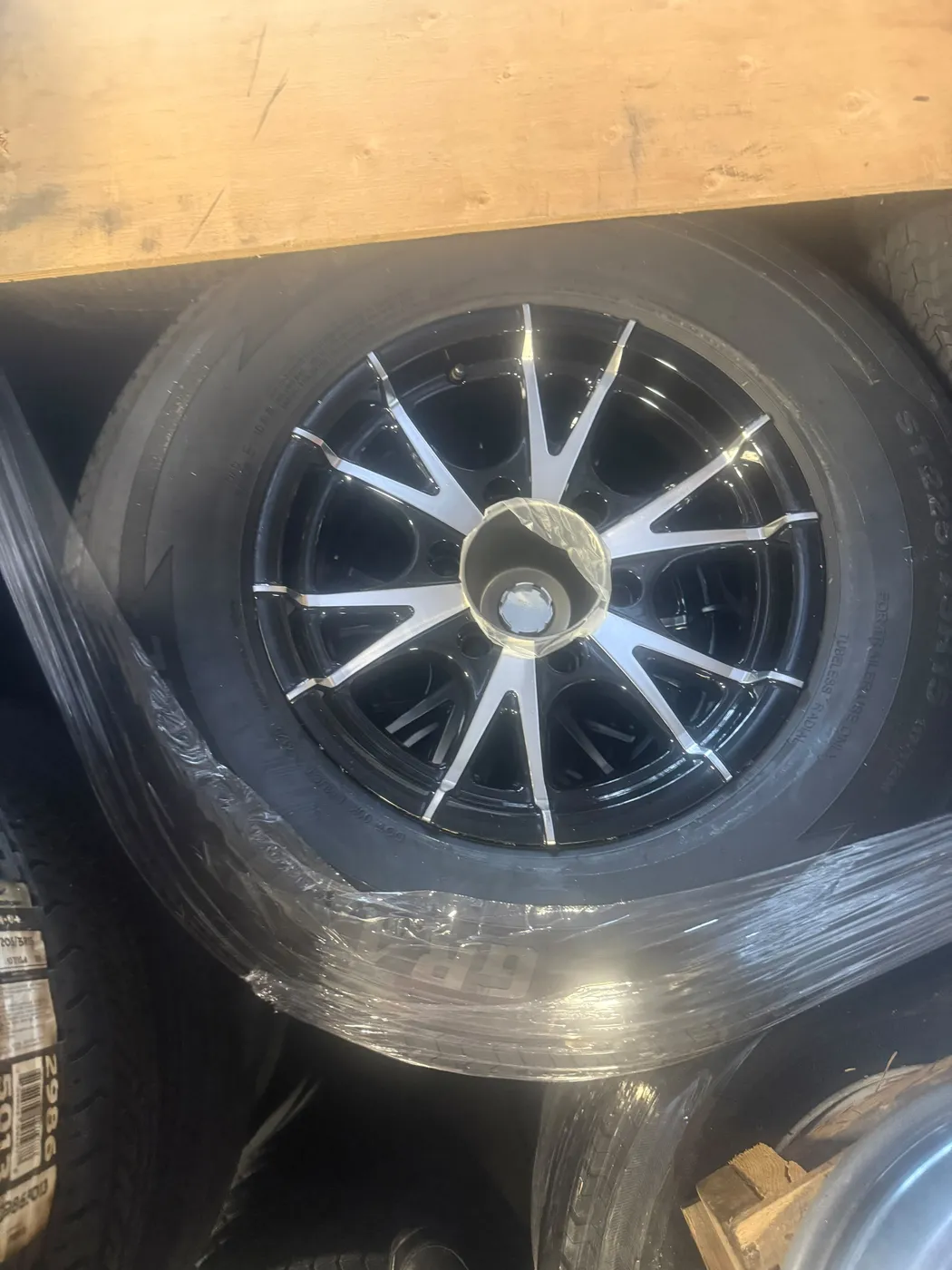 Machined black trailer wheels stacked in the shop
